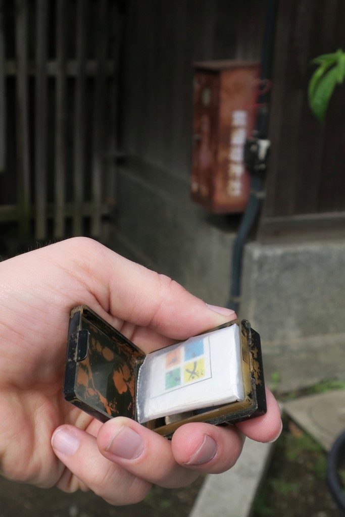 015-geocache_found_under_the_red_box_in_the_background-20160424_143324_g9x_img_0286_cropped_qual100_down1920